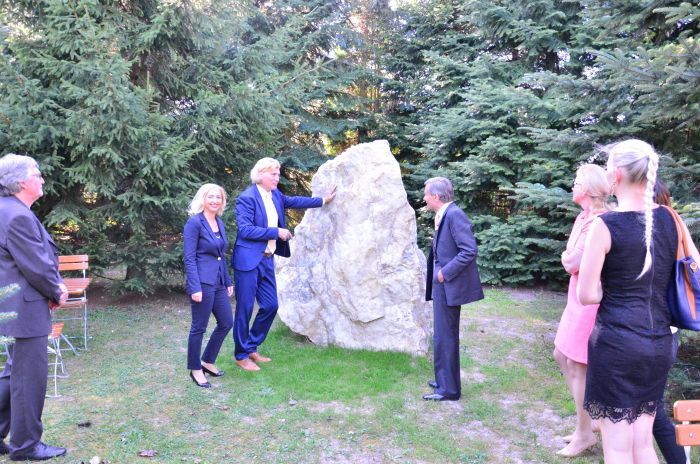 Gäste an einem großen Findling im Park