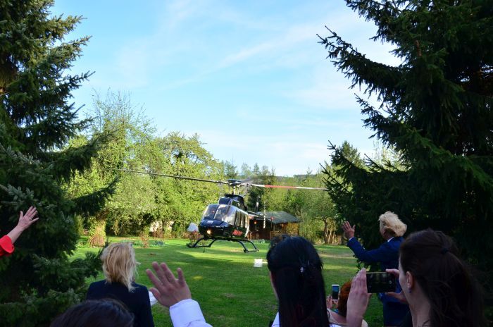Gäste winken dem startenden Hubschrauber zu